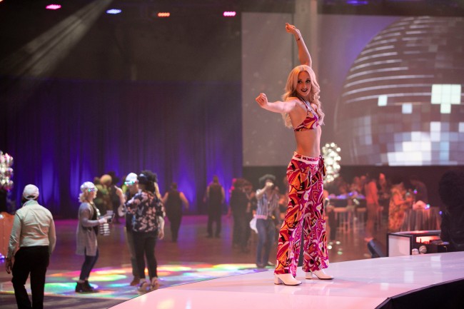 woman in 1960s hip hugger outfit on stage at a corporate meeting event