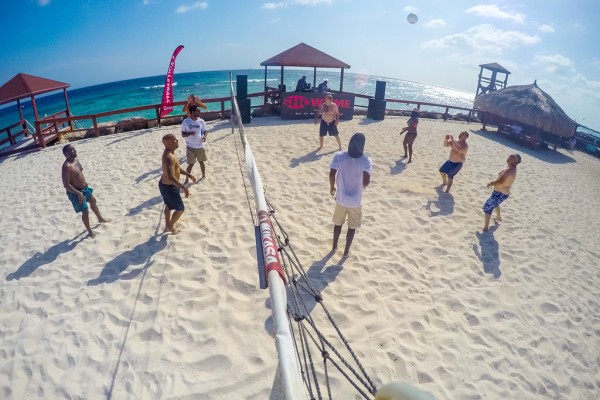 employees play volleyball at incentive event
