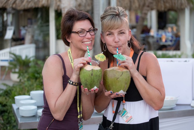 2 women drink from coconuts at Verizon Corporate event