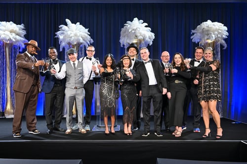 Group toast on event stage in vintage-themed celebration
