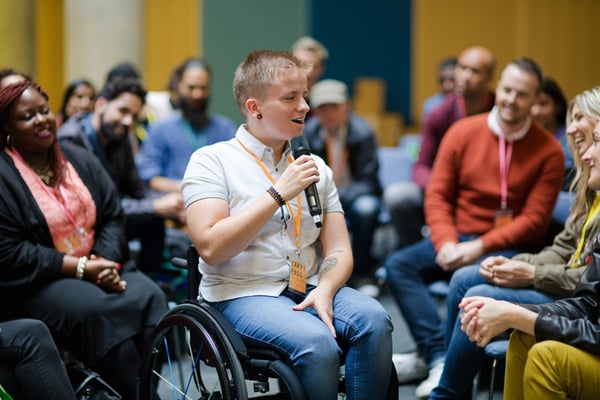 Person in wheelchair talks to group circled around them455875044