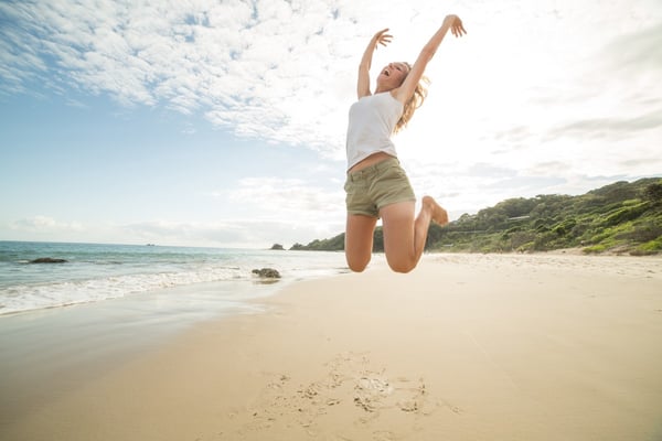 woman celebrates on the beach on an incentive trip