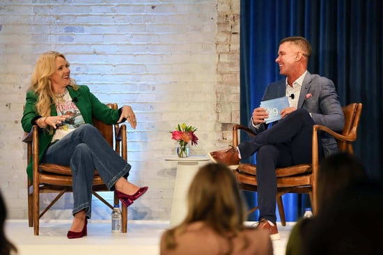 Man and woman on stage sitting in chairs talking