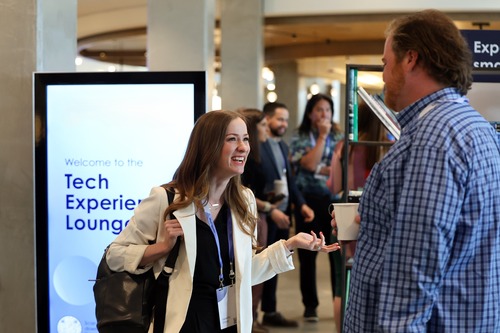 Smiling woman speaking to a man at a tech conference