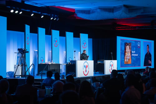 Man speaking on a stage during corporate event