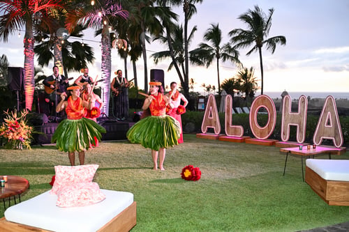 Women dancing in grass skirts during incentive trip