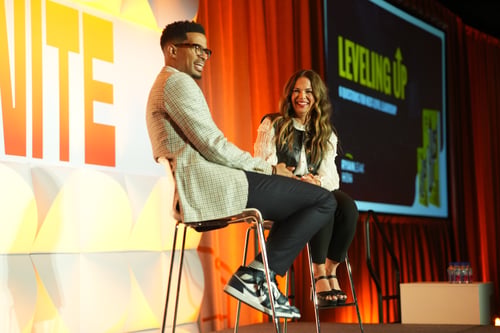 Two speakers sitting on stools during conference session
