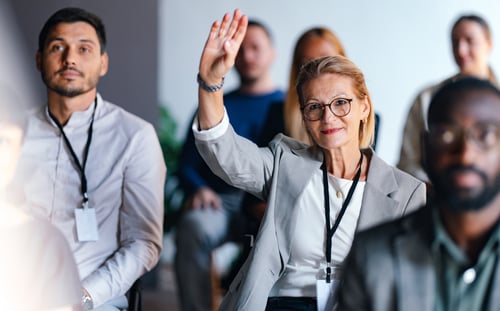 Conference attendee raising their hand