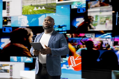 Man holding a tablet speaking at a SaaS event