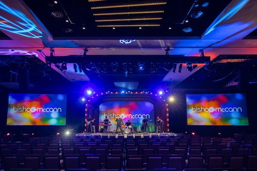 Musicians on a stage backlight with colorful screens and Bishop-Mcann