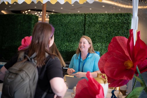 Smiling woman helping event attendee get registered