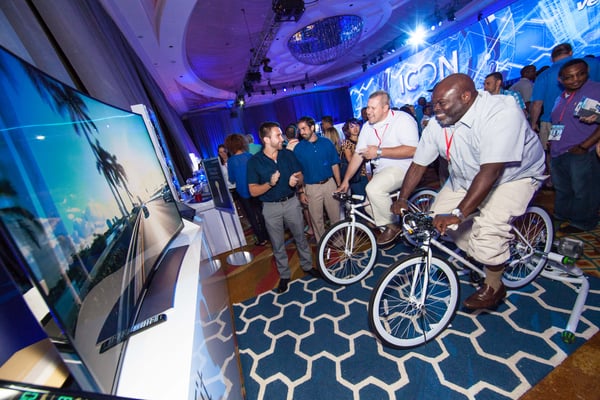 two men cycle on virtual beach at franchise event