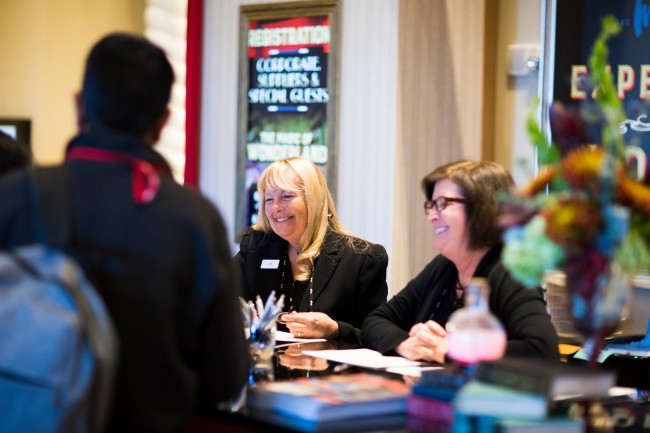 two smiling female customer service agents assist guests