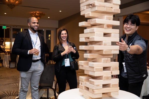 3 coworkers laughing and playing giant jenga