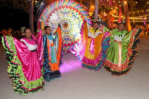 four incentive trip performers in bright dresses smiling