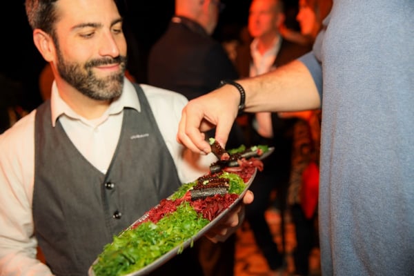 server offers food to corporate event guests