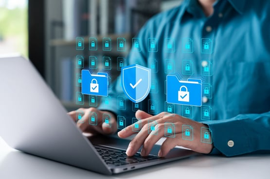 Person typing on a laptop and icons reflecting cybersecurity