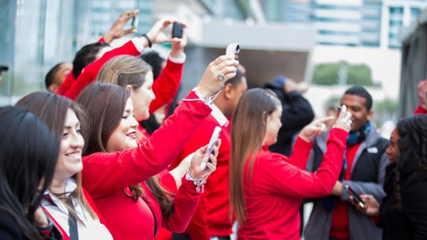Women in red jackets take social media videos at Verizon corporate event